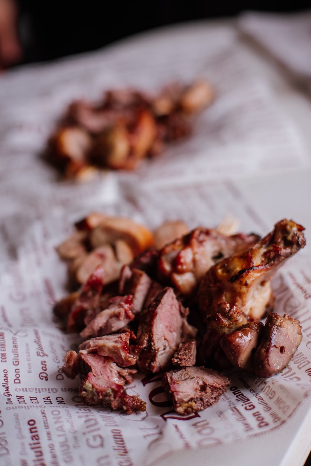Porção de churrasco servida sobre papel com a marca Don Giuliano