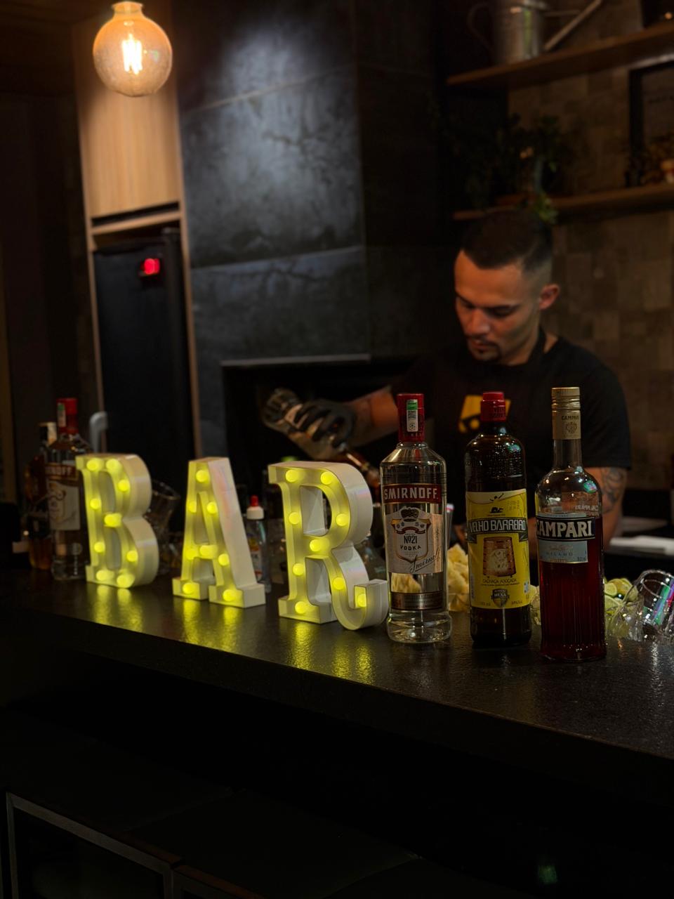 Barman preparando drinks no balcão iluminado