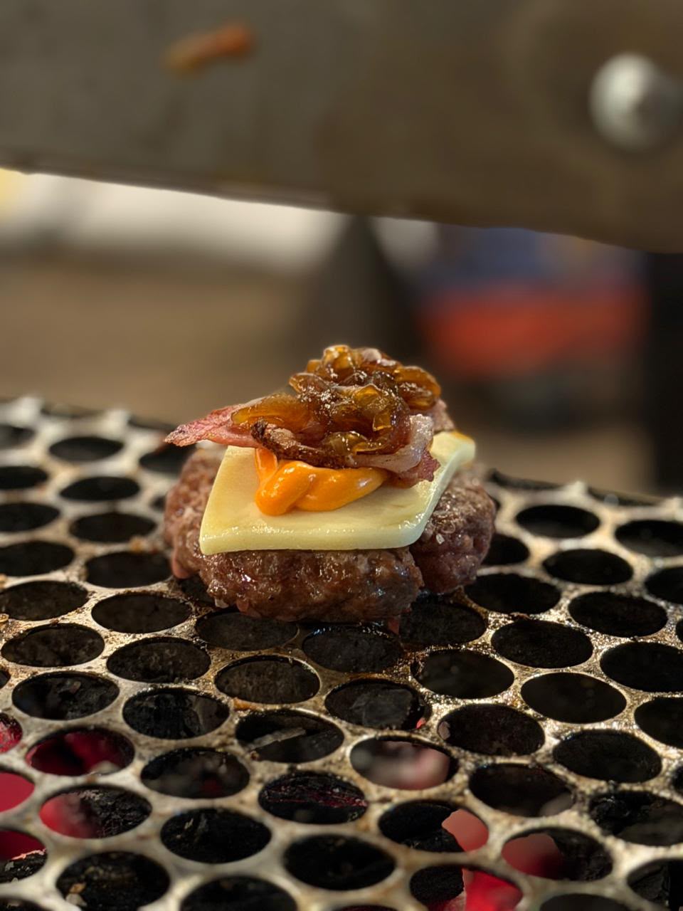 Hambúrguer com queijo, bacon e cebola caramelizada na grelha