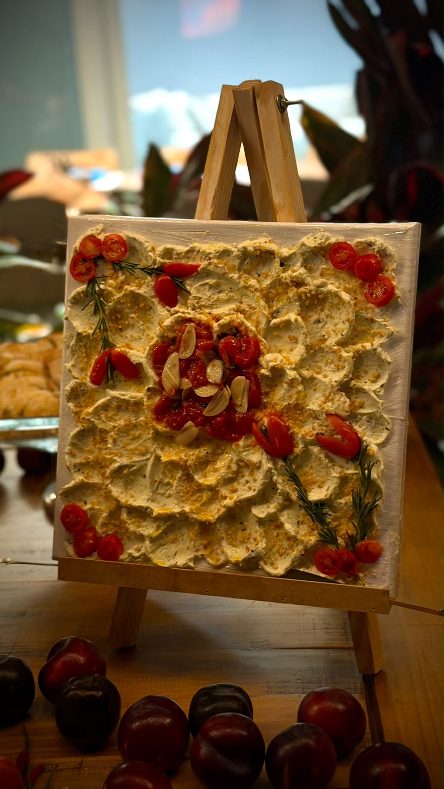 Pasta decorada com tomates e ervas apresentada em um cavalete sobre a mesa