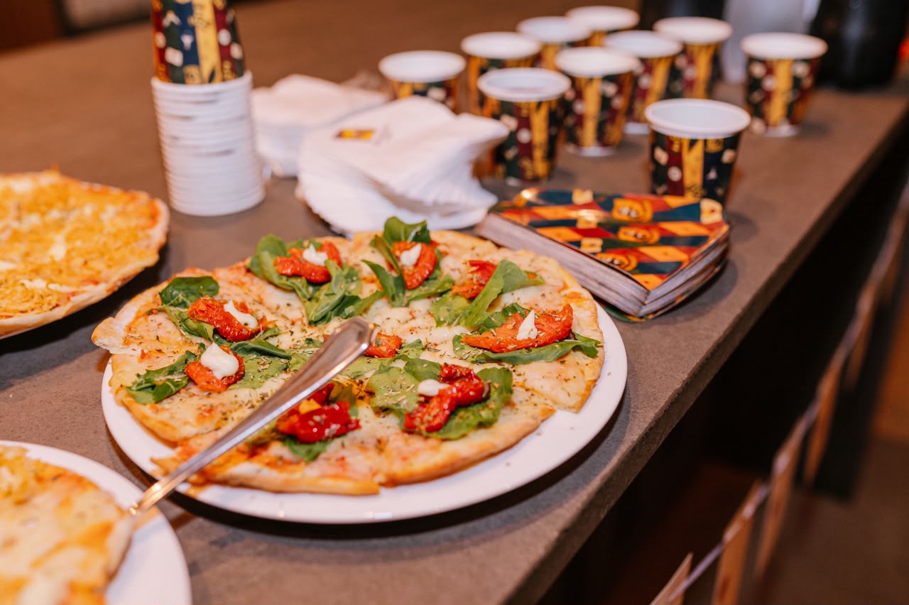 Pizzas artesanais fatiadas sobre o balcão de um evento