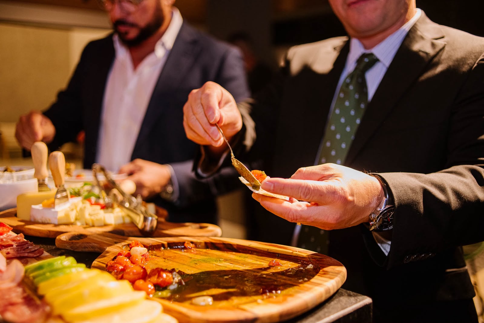 Convidados se servindo na mesa de frios